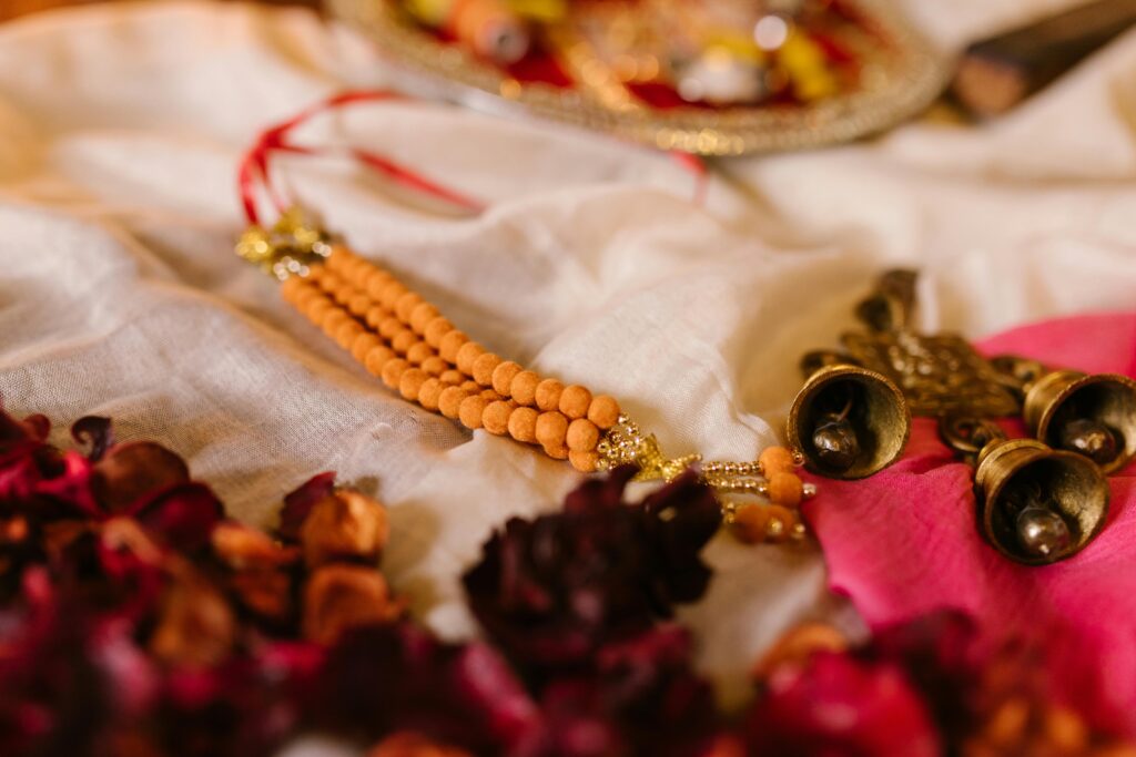 Vibrant Indian jewelry and flowers on a fabric backdrop, perfect for ceremonies.